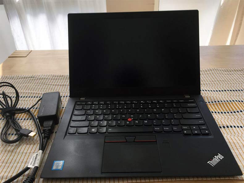 refurbished laptop lenovo t460s sitting on a table with charger 